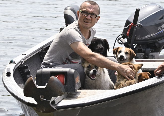 Po razstrelitvi jeza Kahovka na Dnepru so prostovolci reševali, kar se je rešiti dalo, tudi pse. Toku zgodovine je pomagal eksploziv. FOTO Genja Savilov/AFP