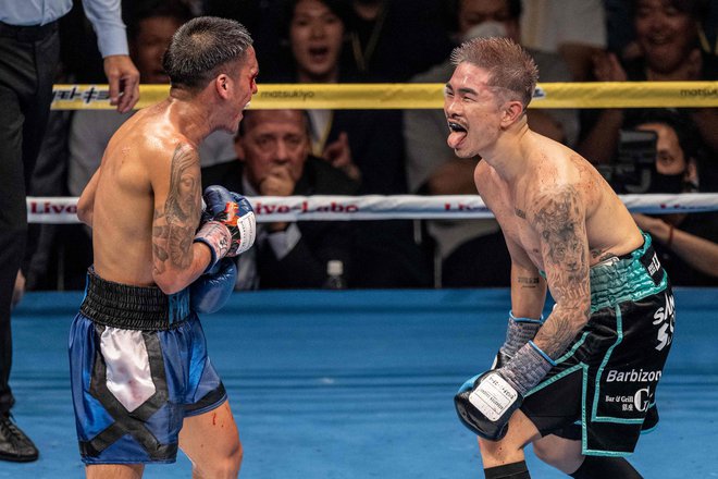 Japonec Kazuto Ioka (desno) se bori proti Američanu Joshui Francu med boksarskim dvobojem za naslov svetovnega prvaka WBA v super mušji kategoriji 24. junija 2023 v Tokiu. Foto: Yuichi Yamazaki/Afp