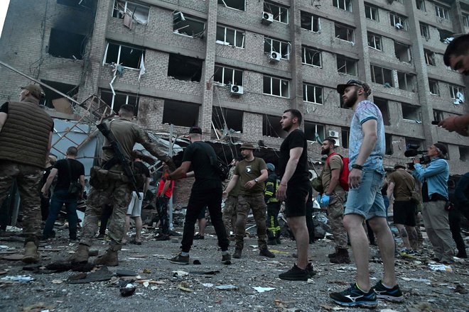 Reševalci in prostovoljci pomagajo ranjenim. FOTO: Genya Savilov/AFP