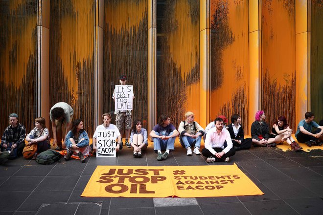 Podnebni aktivisti organizacije Just Stop Oil na sedežu podjetja TotalEnergies v londonskem okrožju Canary Wharf so pripravili sedečo akcijo, na kateri so z oranžno barvo obmetali sedež podjetja v Združenem kraljestvu in protestirali proti gradnji vzhodnoafriškega naftovoda (EACOP). Družba TotalEnergies in Kitajska nacionalna naftna korporacija na morju (CNOOC) sta podpisali 10 milijard dolarjev vreden sporazum o razvoju ugandskih naftnih polj in gradnji naftovoda. Vendar je projekt naletel na močno nasprotovanje aktivistov in okoljskih skupin, ki trdijo, da ogroža krhek ekosistem regije in preživetje več deset tisoč ljudi. Foto: Henry Nicholls/Afp
