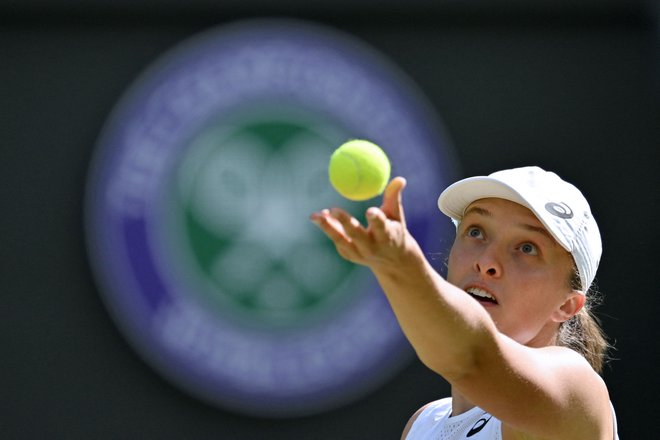 (FILES) Poland's Iga Swiatek serves to France's Alize Cornet during their women's singles tennis match on the sixth day of the 2022 Wimbledon Championships at The All England Tennis Club in Wimbledon, southwest London, on July 2, 2022. Iga Swiatek will attempt to add the Wimbledon title to the US and French Open crowns she already possesses when the third major of the season gets underway on July 3, 2023. (Photo by Glyn KIRK/AFP)/RESTRICTED TO EDITORIAL USE Foto Glyn Kirk Afp