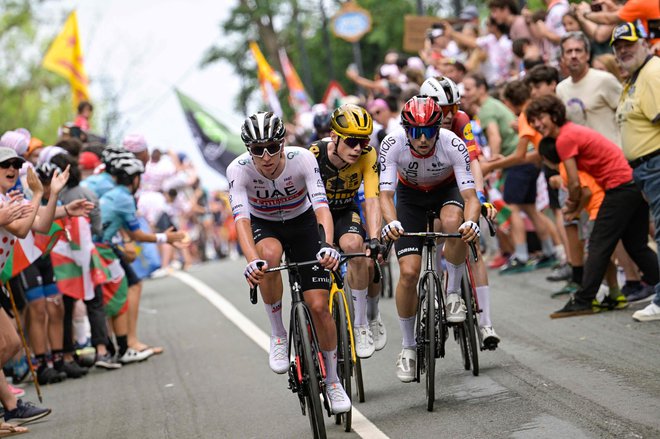 Tadej Pogačar (levo) je potegnil na vzponu na Pike, Jonas Vingegaard (v sredini) mu je sledil, ni pa želel sodelovati v boju za etapno zmago. FOTO: Bernard Papon/AFP