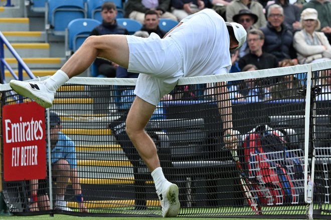 Američan Tommy Paul se je ujel v mrežo med igro z Američanom Jeffreyjem Johnom Wolfom med četrtfinalnim teniškim dvobojem na teniškem turnirju Rothesay Eastbourne International v Eastbournu v južni Angliji. Foto: Glyn Kirk/Afp