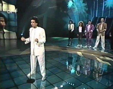 Toto Cutugno na Evroviziji leta 1990 s pesmijo Insieme (Skupaj). V ozadju slovenska spremljevalna skupina. Foto Youtube