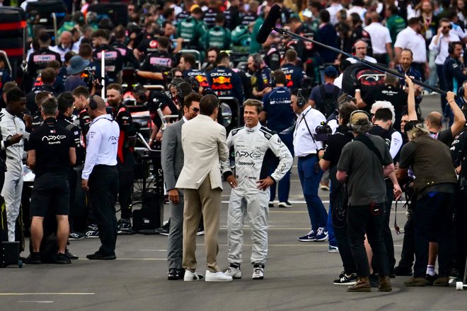 Brad Pitt (v sredini) v vrvežu pred nedeljsko dirko v Silverstonu. FOTO: Ben Stansall/AFP