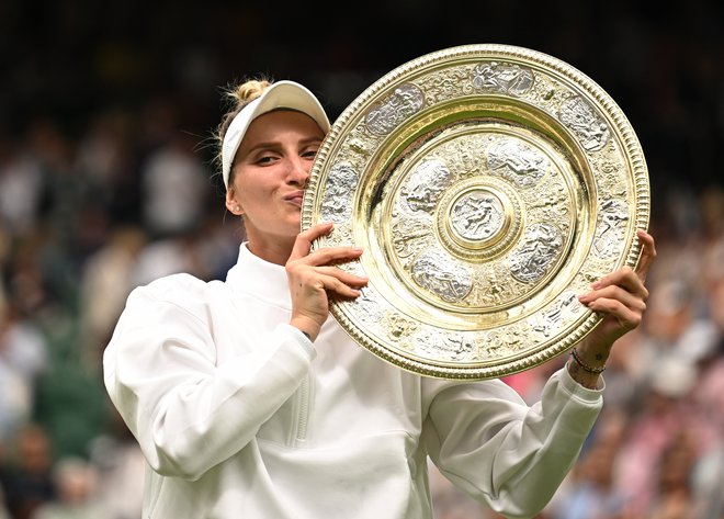 Marketa Vondroušova s trofejnim krožnikom za zmagovalko Wimbledona. FOTO: Dylan Martinez/Reuters