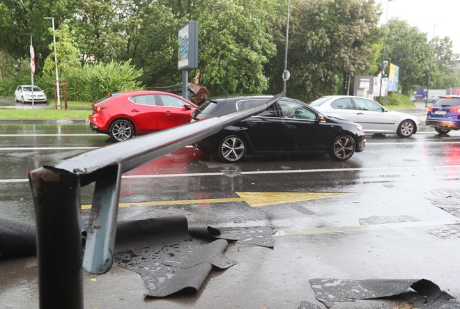 V Ljubljani je pod močjo vetra popustila svetilka javne razsvetljave in padla na enega izmed avtomobilov. FOTO: Dejan Javornik/Slovenske novice