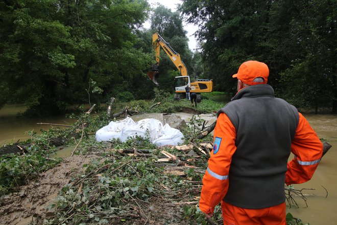 Boj z Muro v Dolnji Bistrici. Vodarji, gasilci in pripadniki civilne zaščite so ob pomoči helikopterja SV zamašili luknjo v visokovodnem nasipu, zaradi katere je grozilo, da bo poplavilo vas. FOTO: Jože Pojbič/Delo