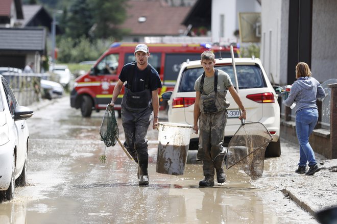 Člani Ribiške družine Mozirje so reševali ribe, ki so splavale iz ribnika. Loke pri Mozirju so bile v celoti pod vodo. FOTO: Leon Vidic