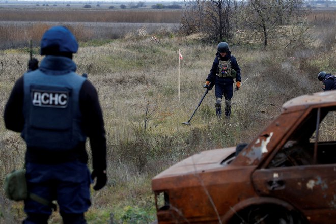 Ukrajinski vojaki preiskujejo minsko polje ob cesti proti Hersonu. FOTO: Murad Sezer/Reuters