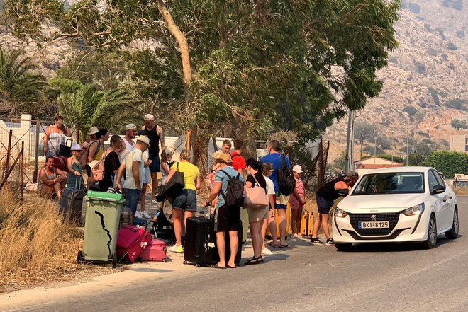 V zadnjih tednih so turiste marsikje evakuirali, zaradi poplav tudi v Sloveniji, pred tem pa so potniki bežali pred požari na Rodosu, od koder je fotografija. FOTO: Lefteris Diamandis/Reuters