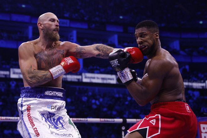 Robert Helenius (levo) je zadal več močnih udarcev Anthonyju Joshui, ki se mu je oddolžil z nokavtom. FOTO: Andrew Couldridge/Reuters