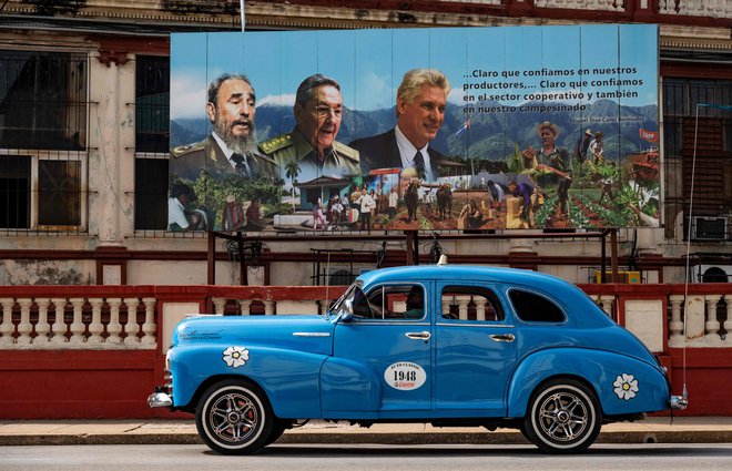 Star ameriški avtomobil pelje mimo plakata pokojnega kubanskega voditelja Fidela Castra, nekdanjega predsednika Raula Castra in sedanjega predsednika Miguela Diaza-Canela v Havani. Foto: Yamil Lage/Afp