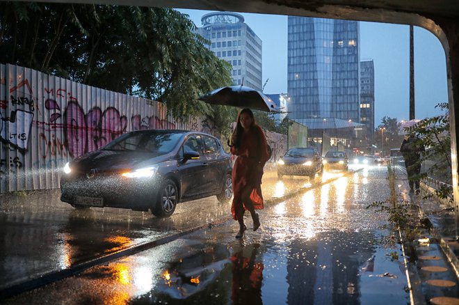 Neurje v Ljubljani. Poplavljeni železniški podvoz na Dunajski cesti je avtomobile pregnal na pločnike. FOTO: Blaž Samec/Delo