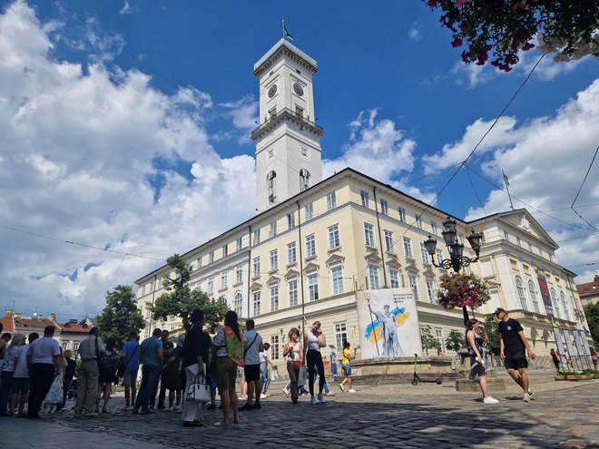 Skupina domačih turistov pred Mestno hišo v Lvovu  FOTO: Marko Gams