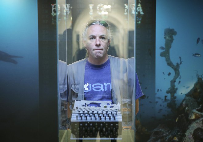 Aleš Jelinčič pred stekleno vitrino, v kateri je na ogled Enigma. FOTO: Jože Suhadolnik/Delo