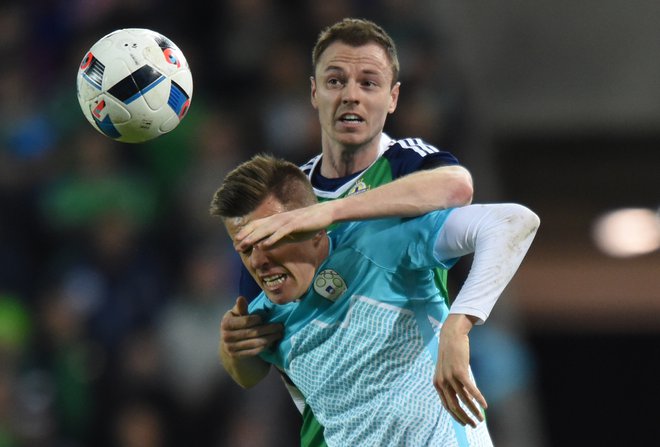 Slovenija in Severna Irska sta se nazadnje pomerili leta 2016, ko je v Belfastu zmagala domača reprezentanca z 1:0. Tako je Jonny Evans oviral slovenskega zvezdnika Josipa Iličića. FOTO: Tony O'Brien/Reuters