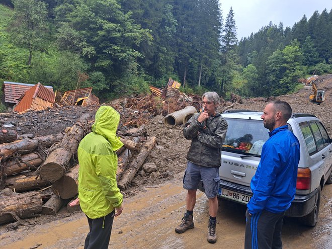 Bernardi Breznik Krajnc in Petru Krajncu je plaz odnesel hišo. Od nje je ostalo, kar se vidi v daljavi. Med njima stoji Primož Planovšek. FOTO: Špela Kuralt/Delo