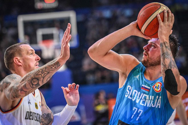 Luka Dončić s povprečjem 26,4 točke ostaja najučinkovitejši strelec letošnjega svetovnega prvenstva. Levo Daniel Theis. FOTO: Juiči Jamazaki/AFP