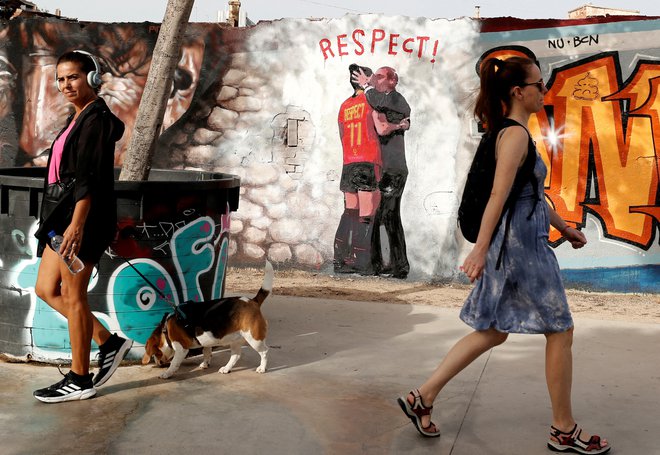 Ženske se sprehajajo mimo stenske poslikave v parku Glories v Barceloni, ki prikazuje sporni poljub vodje španske nogometne zveze Luisa Rubialesa, ki ga je dal nogometašici Jenni Hermoso med praznovanjem ob osvojitvi svetovnega prvenstva. Foto: Bruna Casas/Reuters