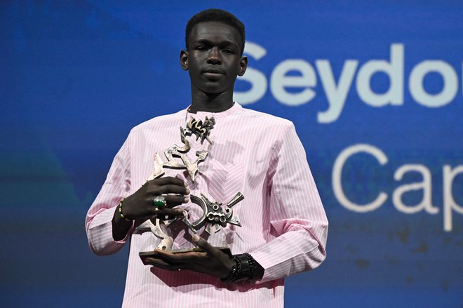 »Hvala vsem, se opravičujem... res sem brez besed,« je bil ob podelitvi nagrade presenečen mladi Senegalec Seydou Sarr. FOTO: Tiziana Fabi/AFP