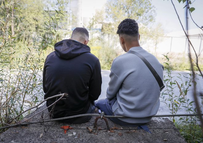 Mladeniča iz Maroka, ki posedata v okolici azilnega doma na Viču.

FOTO: Jože Suhadolnik/Delo