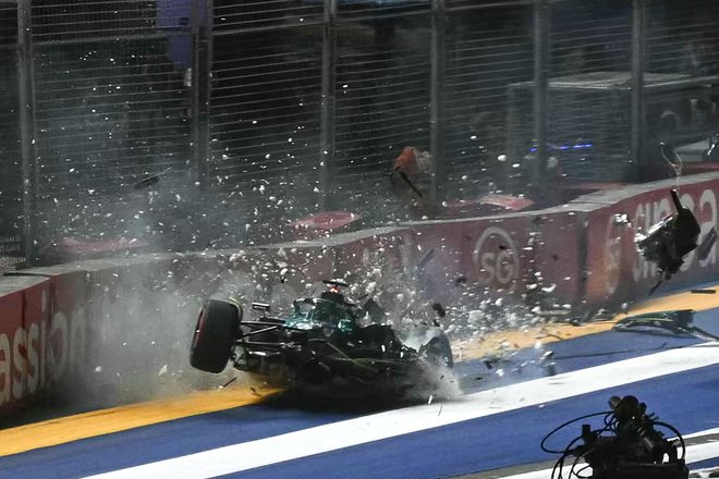 Kanadski dirkač Aston Martina Lance Stroll je trčil v ograjo med kvalifikacijami za nočno dirko za Veliko nagrado Singapurja formule 1 na dirkališču Marina Bay Street Circuit v Singapurju. Grozljiva nesreča Lancea Strolla je zasenčila boj za najboljši štartni položaj na včerajšnji dirki. Kanadski dirkač je sporočil, da je z njim vse v redu, toda trčenje kljub vsemu ni minilo povsem brez posledic, zato se včerajšnje dirke ni udeležil. Foto: Mohd Rasfan/Afp