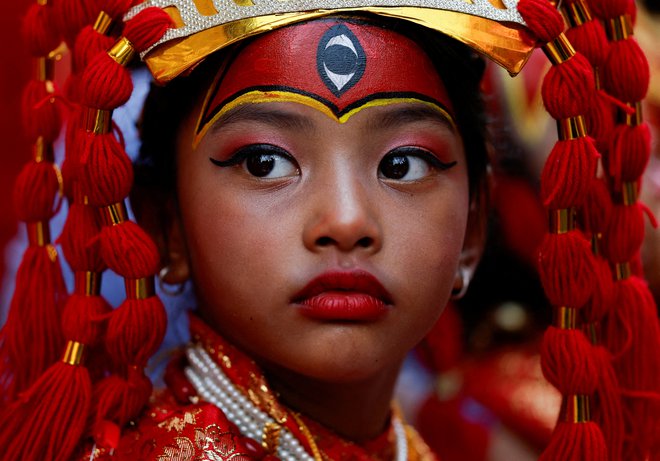 Mlado dekle, oblečeno v boginjo Kumari, se je v Katmanduju, glavnem mestu Nepala, udeležila povorke Kumari pudže, kjer se mlada dekleta predstavljajo kot živa boginja Kumari in jih ljudje častijo v veri, da bodo njihovi otroci zdravi. Foto: Navesh Chitrakar/Reuters