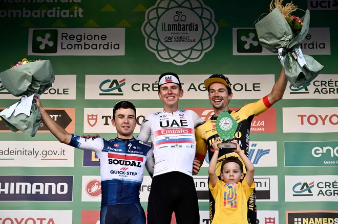 Trije Slovenci na zmagovalnem odru v Bergamu, Tadej Pogačar, Primož Roglič in njegov sin Lev. FOTO: Marco Bertorello/AFP