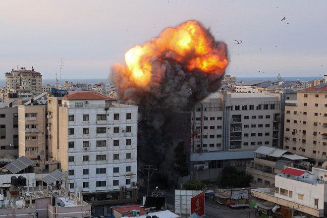 Ogenj in dim se dvigujeta po izraelskem zračnem napadu na Narodno banko v Gazi. FOTO: Ahmed Zakout/AFP