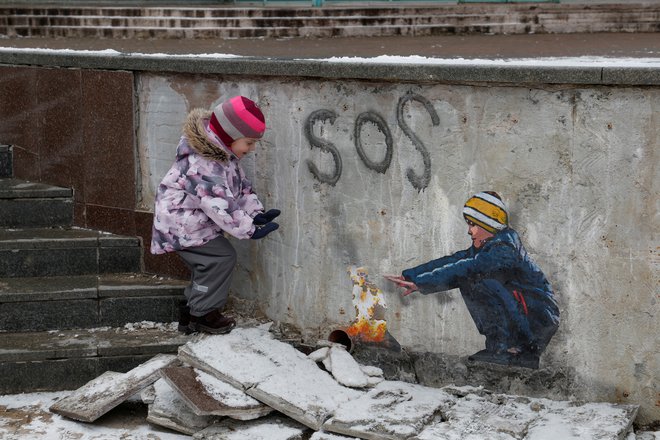 Januar 2023. Štiriletna Anastazija stoji ob umetniškem delu znanega uličnega umetnika Tvboya v središču ukrainskega mesta Buča pri Kijevu. Foto: Valentyn Ogirenko/Reuters