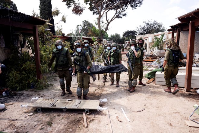 Iz kibuca Kfar Aza odnašajo mrtve. FOTO: Ronen Zvulun/Reuters