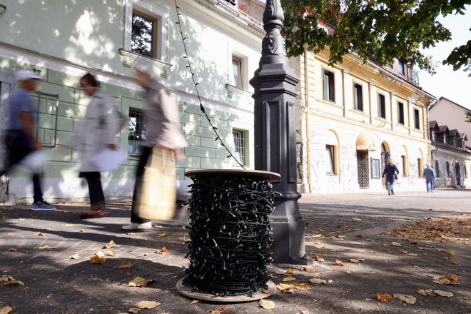 Prve lučke so delavci Javne razsvetljave začeli nameščati na Zmajskem mostu in nadaljevali proti Petkovškovemu nabrežju. FOTO: Črt Piksi/Delo