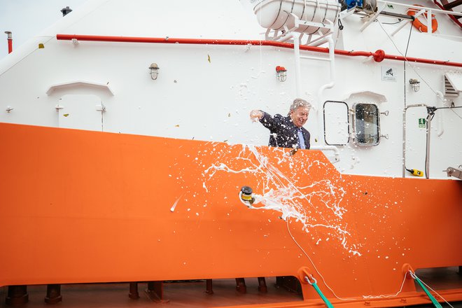 Robert Gerk je moral ročno razbiti steklenico s penino, da je krst novega plovila potrdil, saj je bila steklenica pretrda. FOTO: Jakob Bužan