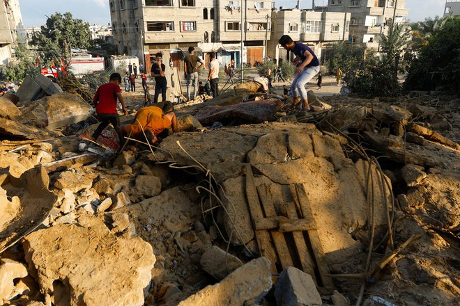 Palestinci iščejo preživele pod ruševinami. FOTO: Ibraheem Abu Mustafa/Reuters