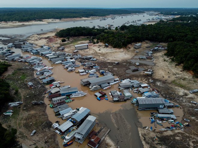 Plavajoče hiše in čolni so zaradi nizkega vodostaja Črne reke nasedli. FOTO: Michael Dantas/AFP