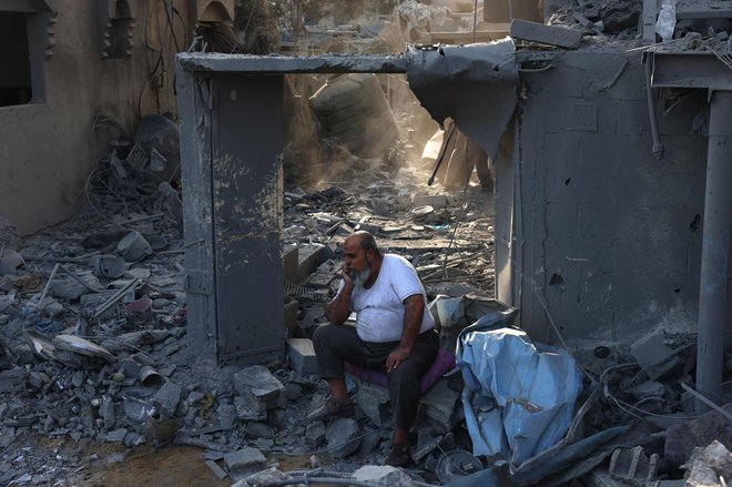 Palestinec sedi na ruševinah hiše, ki so jo uničili Izraelci. FOTO: Said Khatib/AFP