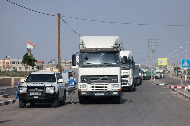 Konvoji pomoči na mejnem prehodu Rafa. Včeraj je vstopilo 14 tovornjakov, kar je po opozorilu ZN le štiri odstotke potrebne pomoči.  FOTO: Mohamed Abed/AFP