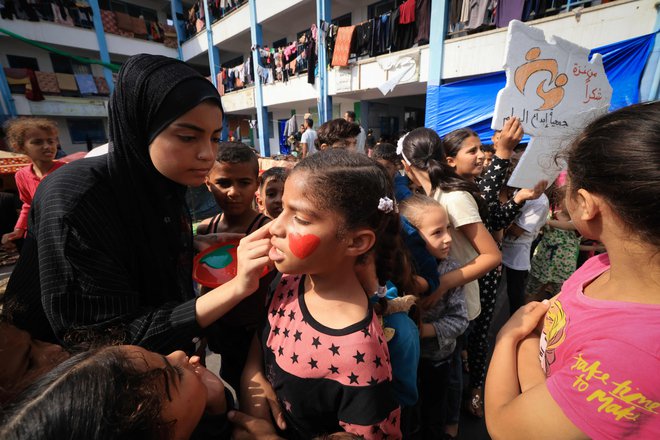 Palestinski otroci, ki so morali zapustiti svoje domove, med igrami v šoli v Gazi, ki so jih organizirali humanitarni delavci. FOTO: Mahmud Hams/AFP