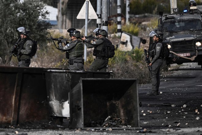 Izraelski vojaki streljajo na palestinske protestnike, ki so na Zahodnem bregu protestirali v znak solidarnosti z Gazo. FOTO: Aris Messinis/AFP