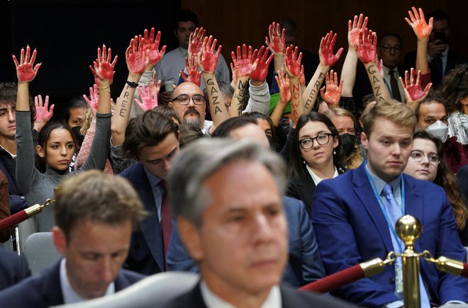 Vsi v ZDA se ne strinjajo s podporo Izraelu. Protivojni protestniki so ob nastopu državnega sekretarja Antonyja Blinkna v senatu dvignili krvave roke. FOTO: Kevin Lamarque/Reuters