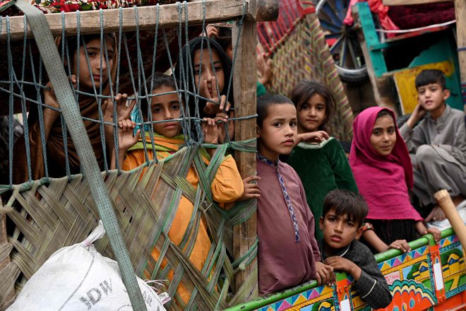 Afganistanski begunci prihajajo s tovornjaki iz Pakistana na afganistansko-pakistansko mejo Torkham v provinci Nangarhar. Islamabad je v začetku oktobra postavil ultimat 1,7 milijona Afganistancem, ki po njegovem mnenju nezakonito živijo v Pakistanu: zapustijo ga do 1. novembra ali pa jih čaka aretacija in izgon. Foto: Wakil Kohsar/Afp