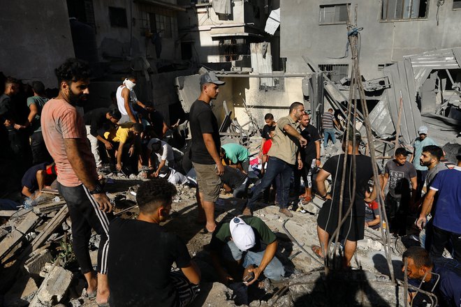 Iskanje palestinskih žrtev po izraelskem napadu na jugu Gaze. FOTO: Abu Mustafa/Reuters