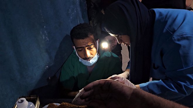 Zdravljenje ranjenih med izpadom elektrike v indonezijski bolnišnici na severu Gaze, kjer je bilo ubitih vsaj dvanajst ljudi. FOTO: REUTERS/Anas al-Shareef