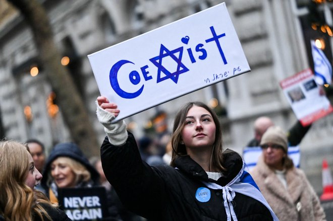 Protestnica med demonstracijami v središču Londona v znak protesta proti antisemitizmu drži napis »Sožitje«. Foto: Justin Tallis/Afp