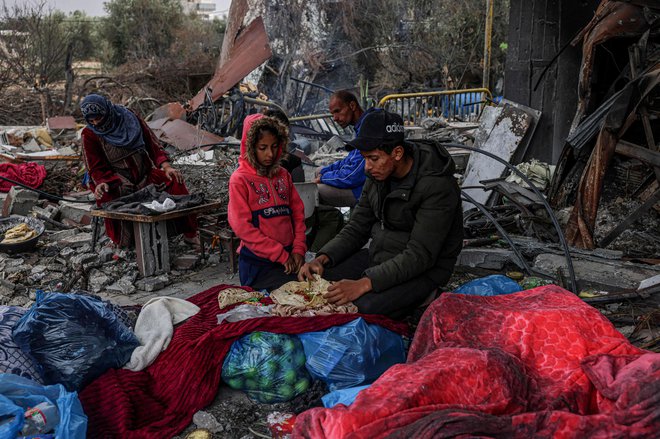 Palestinci pripravljajo obrok v porušeni vasi Khuzaa vzhodno od Khan Yunisa, blizu mejne ograje med Izraelom in južno Gazo, med premirjem v spopadih med Izraelom in palestinsko militantno skupino Hamas. Izraelska vlada je danes sporočila, da je Hamas opozorila, da je možnost podaljšanja premirja na območju Gaze odprta. Foto: Said Khatib/Afp
