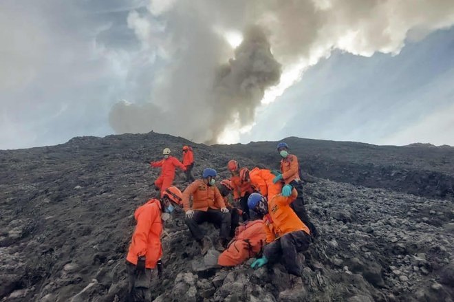 Reševalci evakuirajo eno od žrtev s pobočja gore Marapi na zahodni Sumatri. Na stotine indonezijskih reševalcev je 5. decembra iskalo desetih pohodnikov, ki so izginili po izbruhu vulkana, v katerem je umrlo 13 ljudi. Foto: Handout/Afp