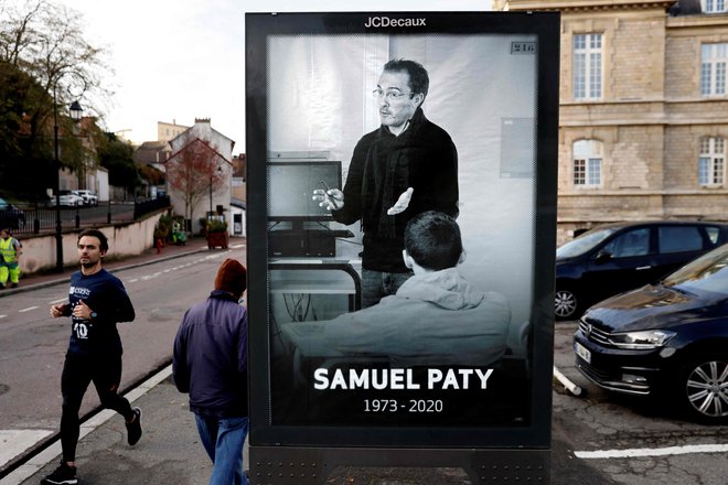 Pešci hodijo mimo oglasne površine, ki prikazuje umorjenega učitelja Samuela Patyja (3. november 2020). FOTO: Thomas Coex/AFP