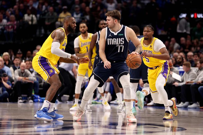 Luka Dončić je z enim očesom spremljal obrambno gibanje LeBrona Jamesa (levo), z drugim opazoval, kje so njegovi soigralci. FOTO: Tim Heitman/AFP