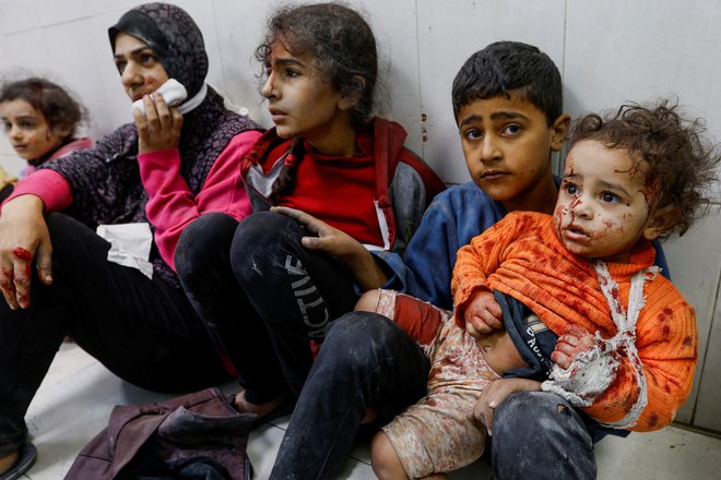 Ranjeni palestinski otroci sedijo na tleh v bolnišnici Nasser v mestu Khan Younis na jugu Gaze po izraelskih bombnih napadih, ki so posledica konflikta med Izraelom in palestinsko islamistično skupino Hamas. Foto: Ibraheem Abu Mustafa/Reuters